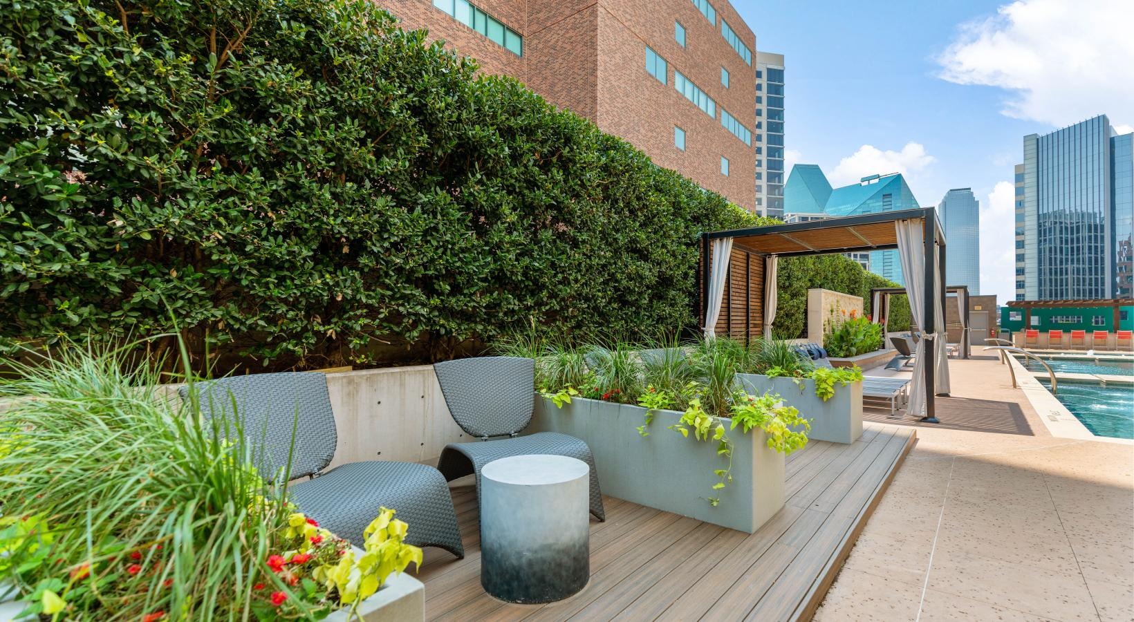 A perfect fit for the whole family a deck with chairs and plants on it by a building